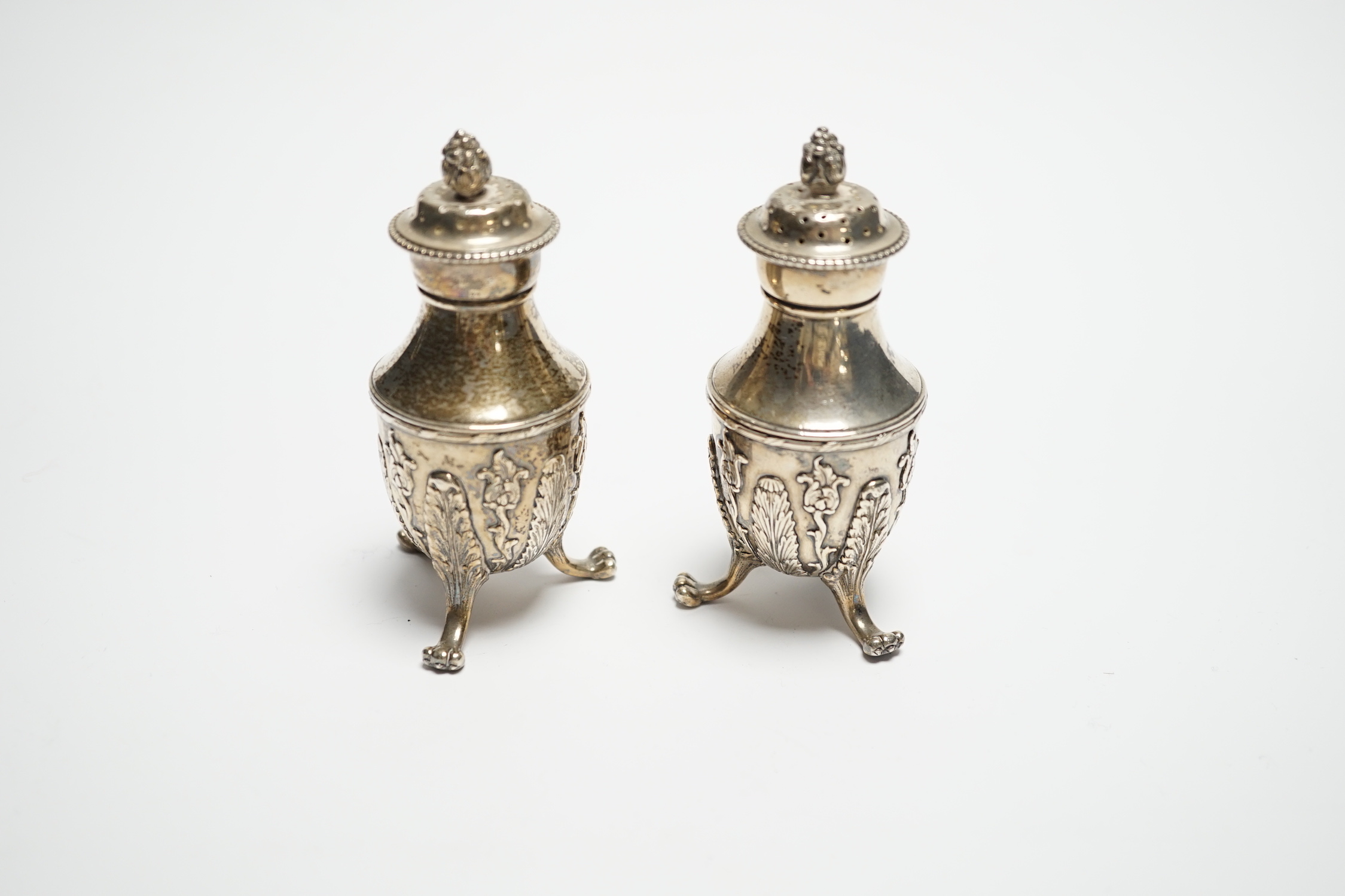 A pair of late 19th century Tiffany & Co sterling pepperettes, on tripod supports, 9cm, 157 grams.